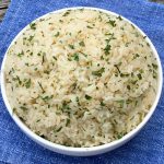 White bowl of rice pilaf on blue napkin