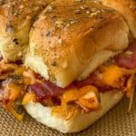 Shredded chicken slider on sweet roll with cheddar, bacon and ranch