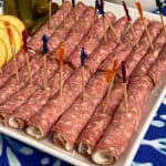 Salami roll-ups with party toothpicks on white plate