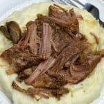 Tender shredded farmhouse pot roast on mashed potatoes