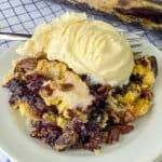 Vanilla ice cream on top of blueberry crunch cake