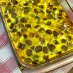 Breakfast casserole with turkey sausage links, eggs and cheese on red plaid napkin
