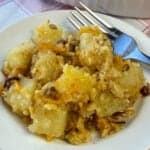 Best cheddar cheese and baked pineapple casserole on a plate with a fork