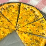 Pillsbury crescent dough breakfast pizza with cheddar cheese, crumbled sausage and scrambled eggs