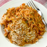 Cheesy chicken parmesan with a fork and light coating of bread crumbs with Italian seasoning