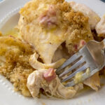 Close up fork full of tender and juicy chicken cordon bleu casserole