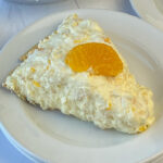 Mandarin orange sitting on top of a slice of no-bake mandarin orange pie