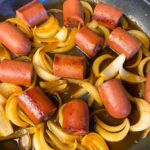 Chunks of Kielbasa in a sweet bbq sauce nestled in softened slices of onions