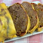 Close up of cheesy ground beef meatloaf recipe with bacon and two types of cheese.