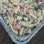 Corner of a pan filled with a simple ranch pasta salad that is great for big crowds.