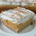 A wonderful Pumpkin Cream Puff Cake made with layers of creamy pudding, cream cheese, pumpkin pie filling and Cool Whip rest on a puffy crust to create a delicious pumpkin dessert.