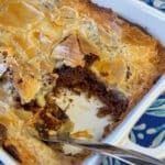 Serving spoon in a corner of german chocolate cake mix with a thick layer of cream cheese baked on top with a very uneven finish.