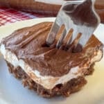 Close up fork ready to scoop up a bit of a chocolate mud cake with three delicious layers including marshmallow cream in the center.