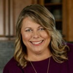 Jennifer, author of Plowing Through Life, smiling in kitchen.