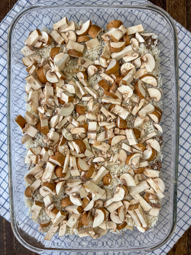Chopped mushrooms in a layer over top of raw rice and cooked hamburger in a 9 13" glass dish.