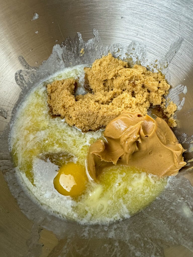 Mixing bowl with melted butter, egg, brown sugar, vanilla and peanut butter.