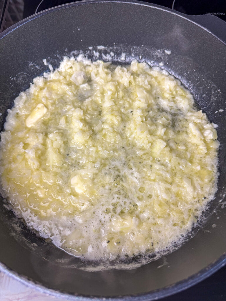 Onions saut&eacute;ing in a lot of butter in a skillet.