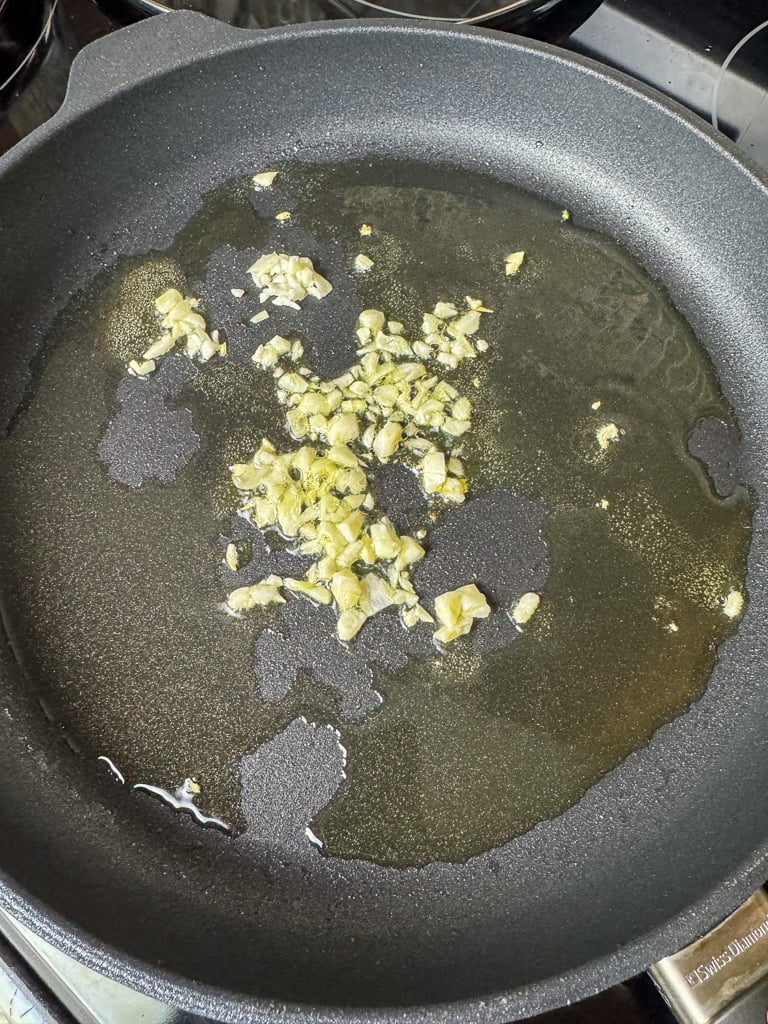 Non-stick skillet with hot oil, garlic and ginger.