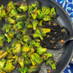 Warm Asian broccoli sautéed in an easy soy sauce with undertones of ginger and garlic in a skillet to create and easy side dish recipe.