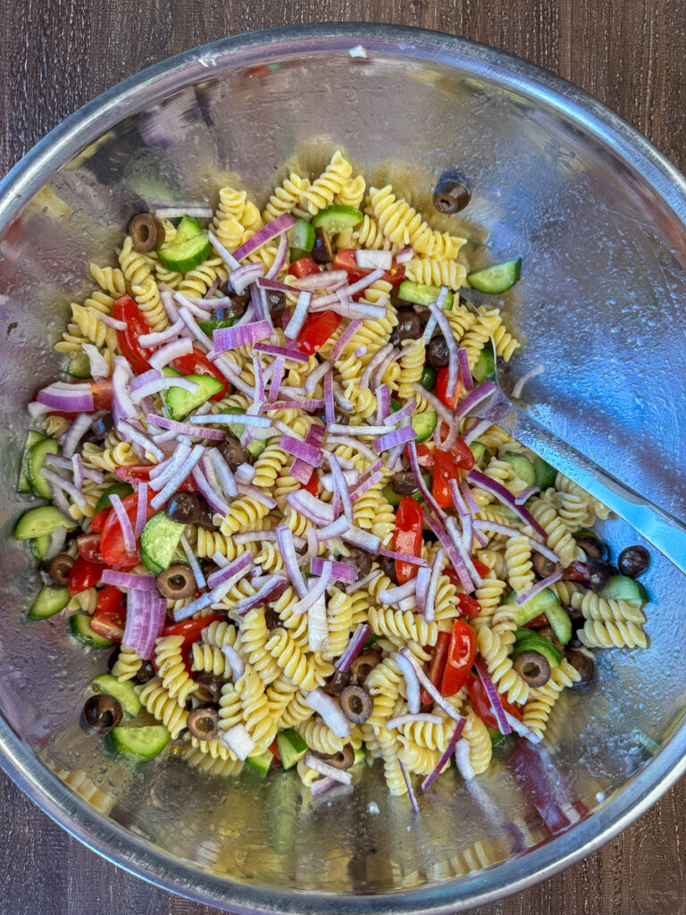Slices of red onion added to a Greek style salad.