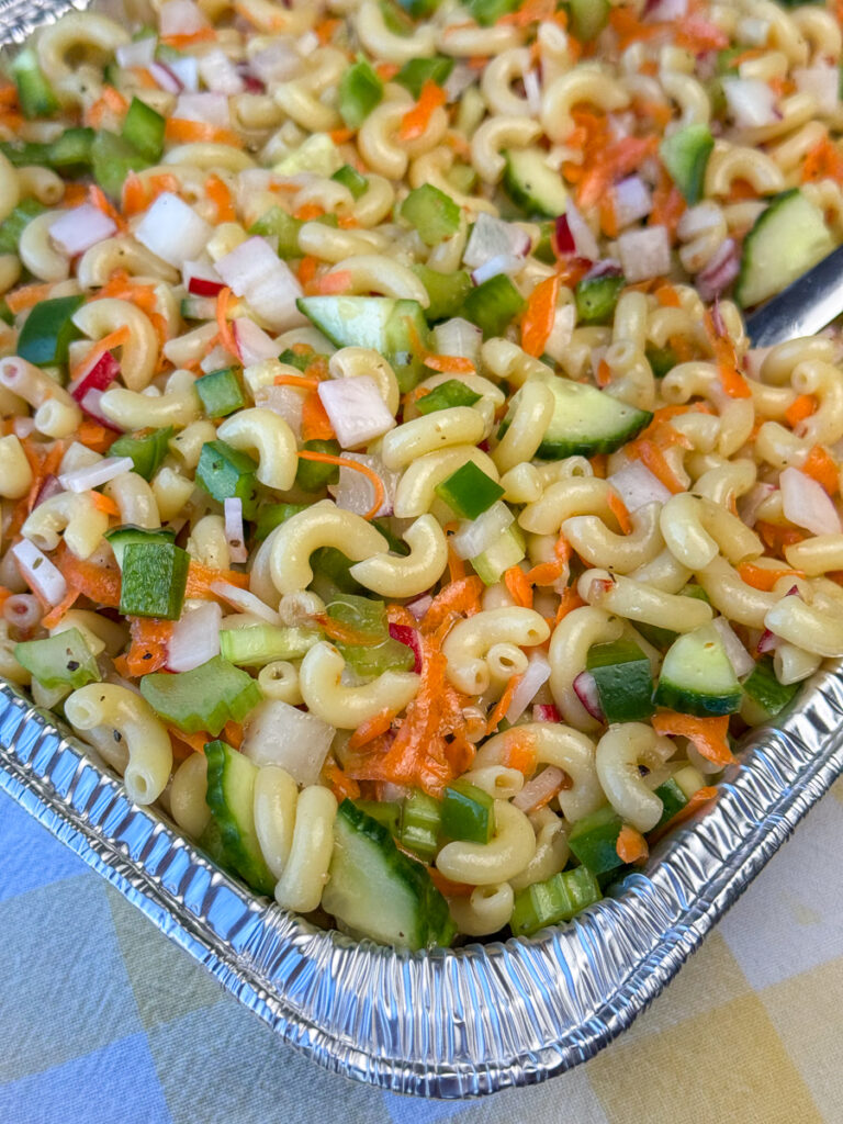 Crunchy celery, cucumber and radishes mixed in with shredded carrots into a delicious macaroni salad with Italian Dressing in a foil pan.