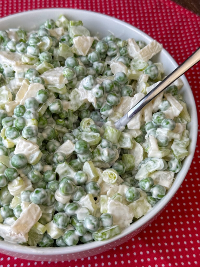 Side view of a bowl with cold and crunchy pea salad made from only 7 ingredients.