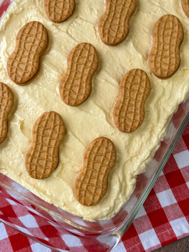 Close up overhear view of a creamy vanilla pudding and cream cheese mixture with layers of bananas and Nutter Butter cookies to make a delicious dessert.
