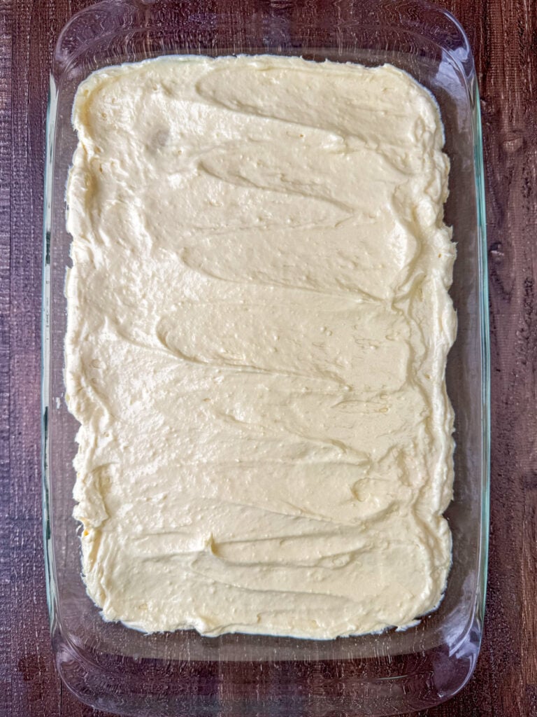Cream cheese and condensed milk pudding mixture spread over peanut butter cookies with a layer of sliced bananas in the center.