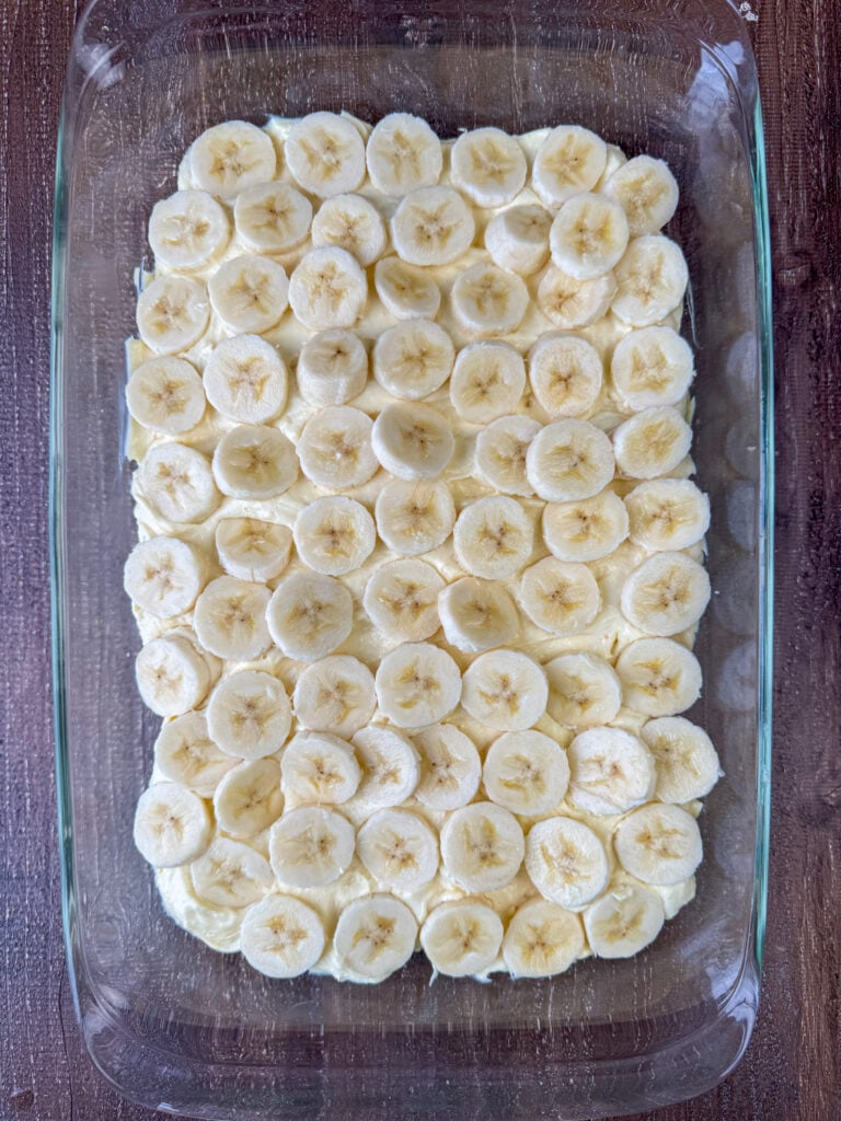 Slices of banana laid over a layer of pudding mixture.