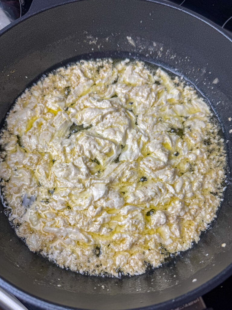 Block of cream cheese and melted butter in a non-stick skillet.