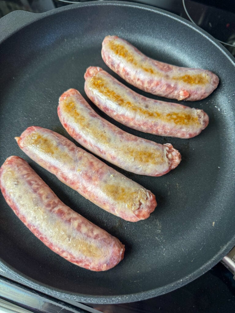 Lightly browning brats on each side in a non-stick skillet.