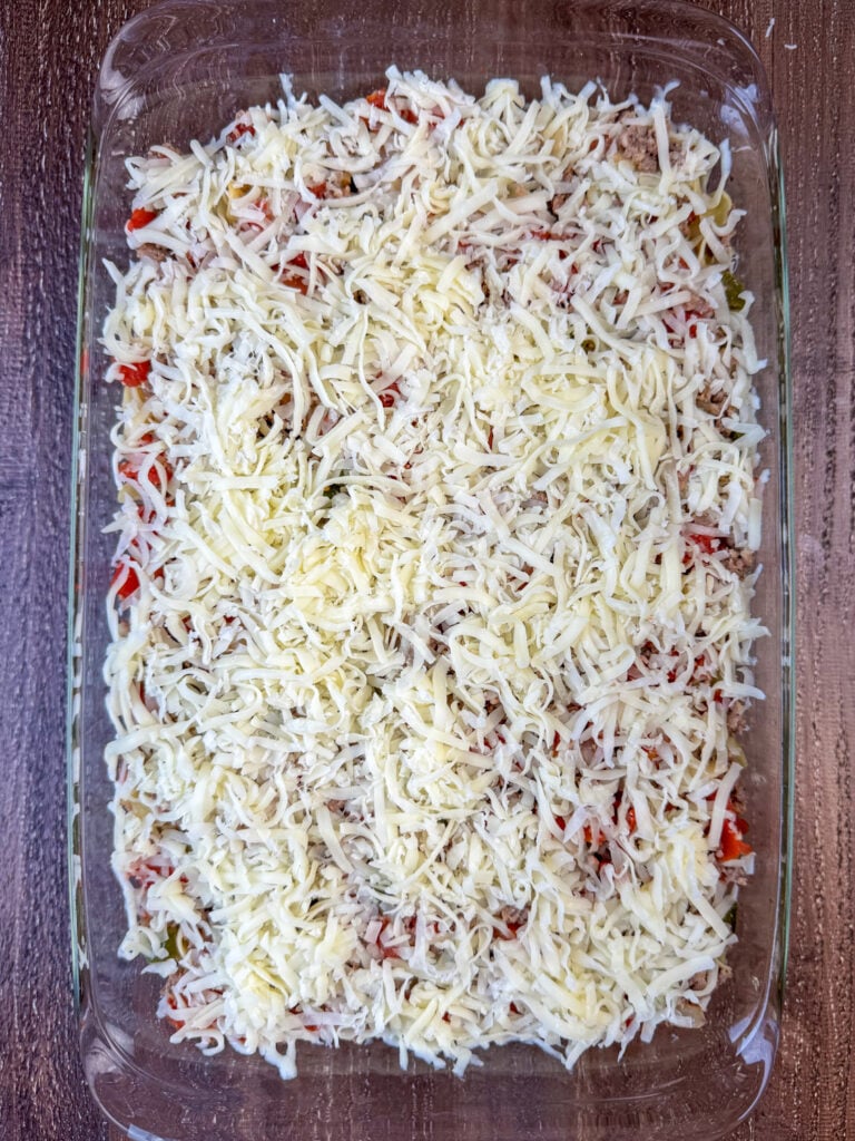 Thick layer of shredded Mozzarella cheese spread over a sausage and zucchini casserole.