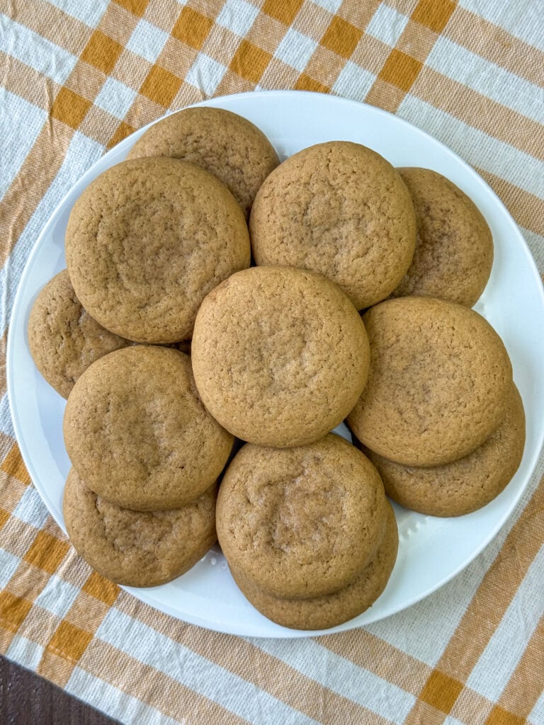 Overhead view of a stack of old fashioned caramel cookies on a white plate.