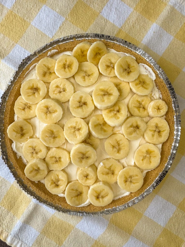 Layer of sliced bananas on a thick cream cheese base in a graham cracker pie crust.