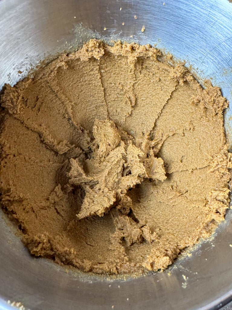 Coarse texture of brown sugar and butter beaten together in a mixing bowl.