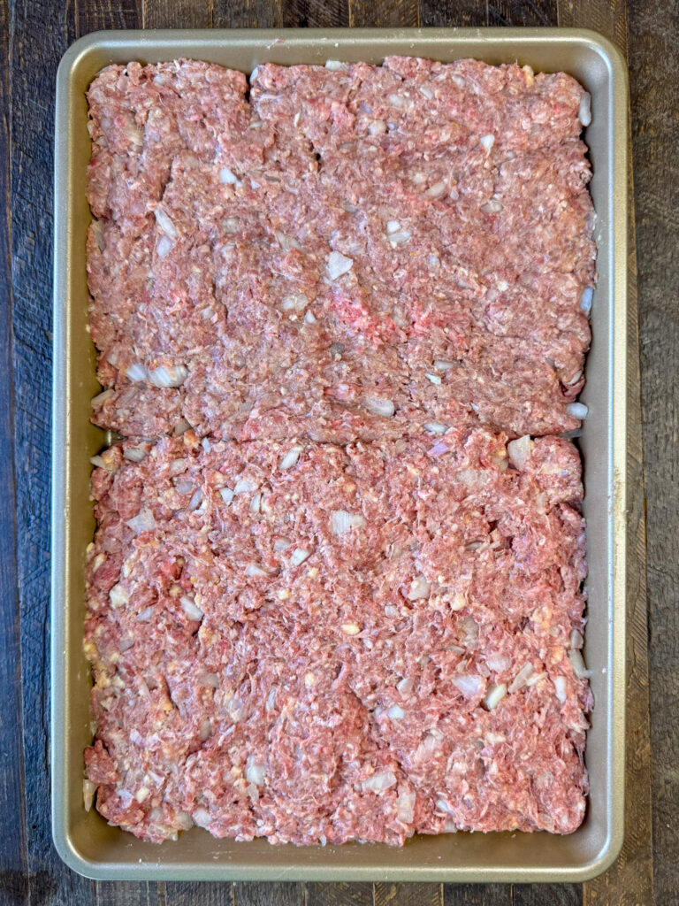 Hamburger steaks patted flat into a baking sheet to chill over night.