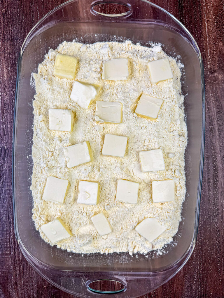 Slices of butter arranged over a layer of classic yellow cake mix.