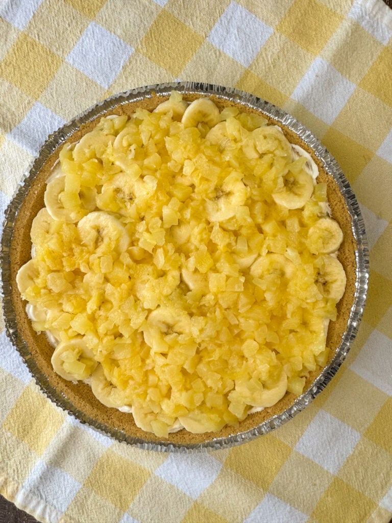 Layer of crushed pineapple spread over slices of bananas in a no bake pie.