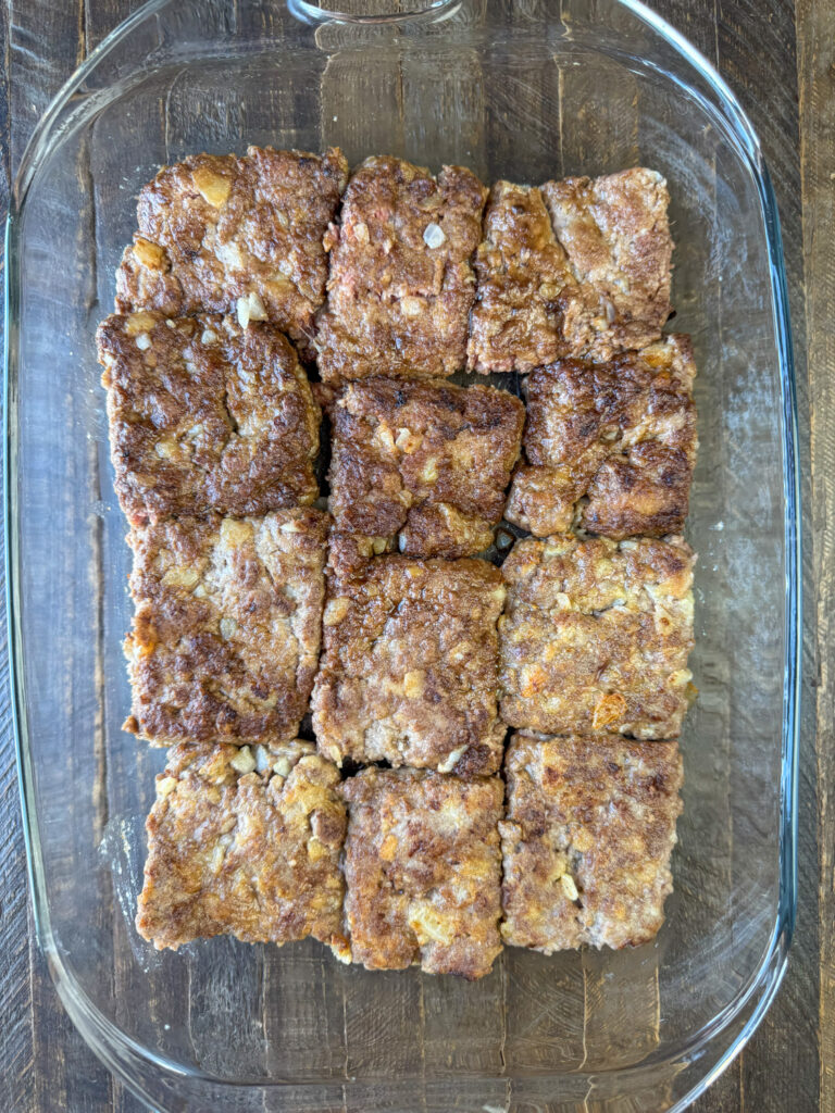 Browned hamburger steaks arranged in a 9 x 13" pan before baking in the oven.