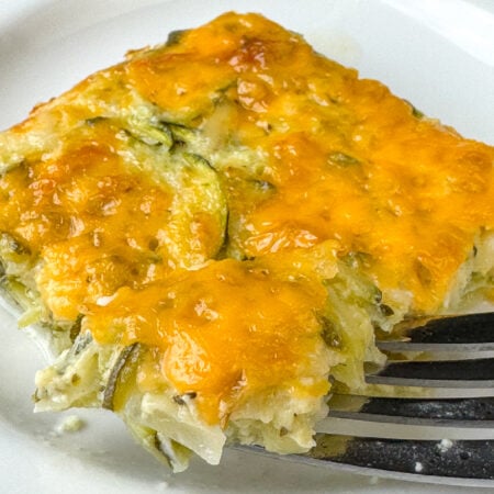 Close up layer of cheese on a zucchini and cottage cheese mixture with onions.