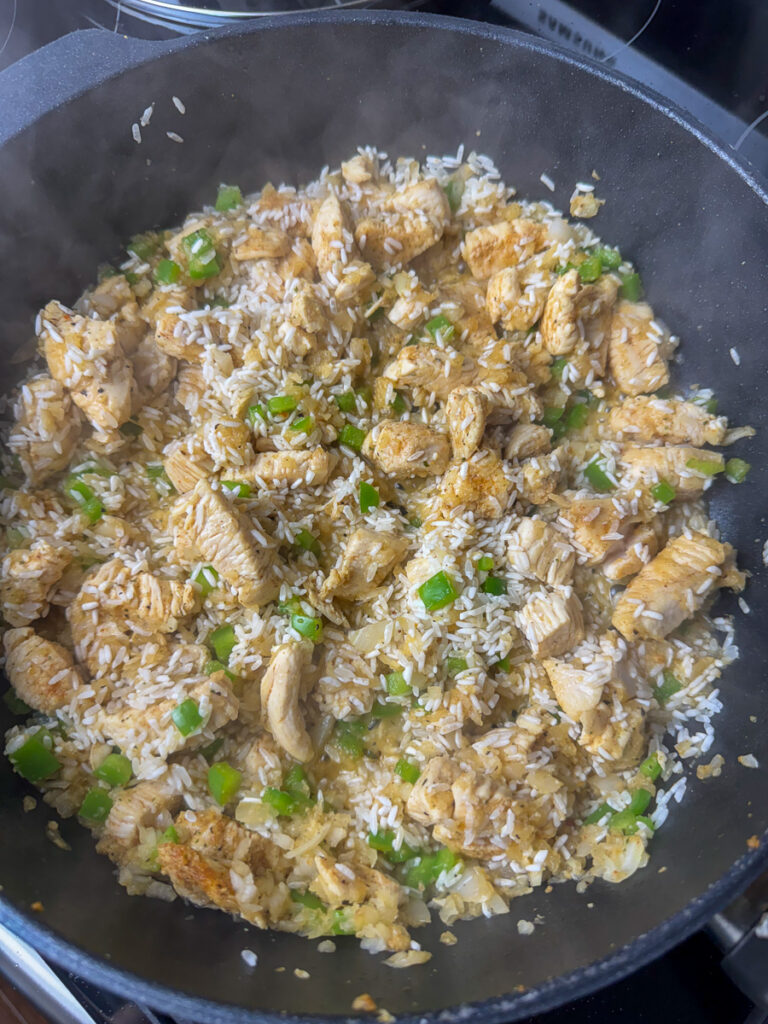 Rice stirred into a hot skillet of chicken to lightly brown.