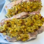 Side view of thick pork chops generously filled with an easy stuffing recipe and baked in the oven.